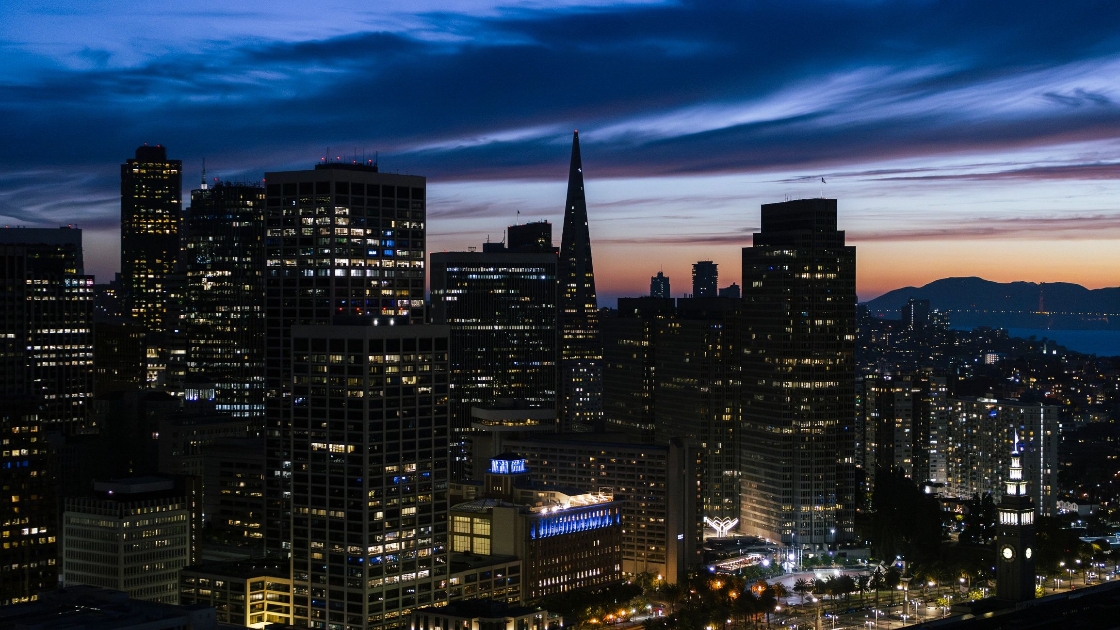 City skyline at sunset representing the broader economy and financial markets